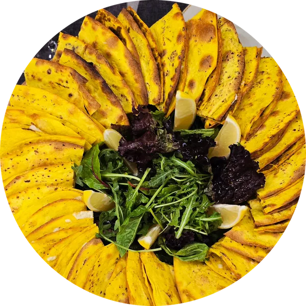 Lahmajo set laid out like a sunflower around greens and lemon